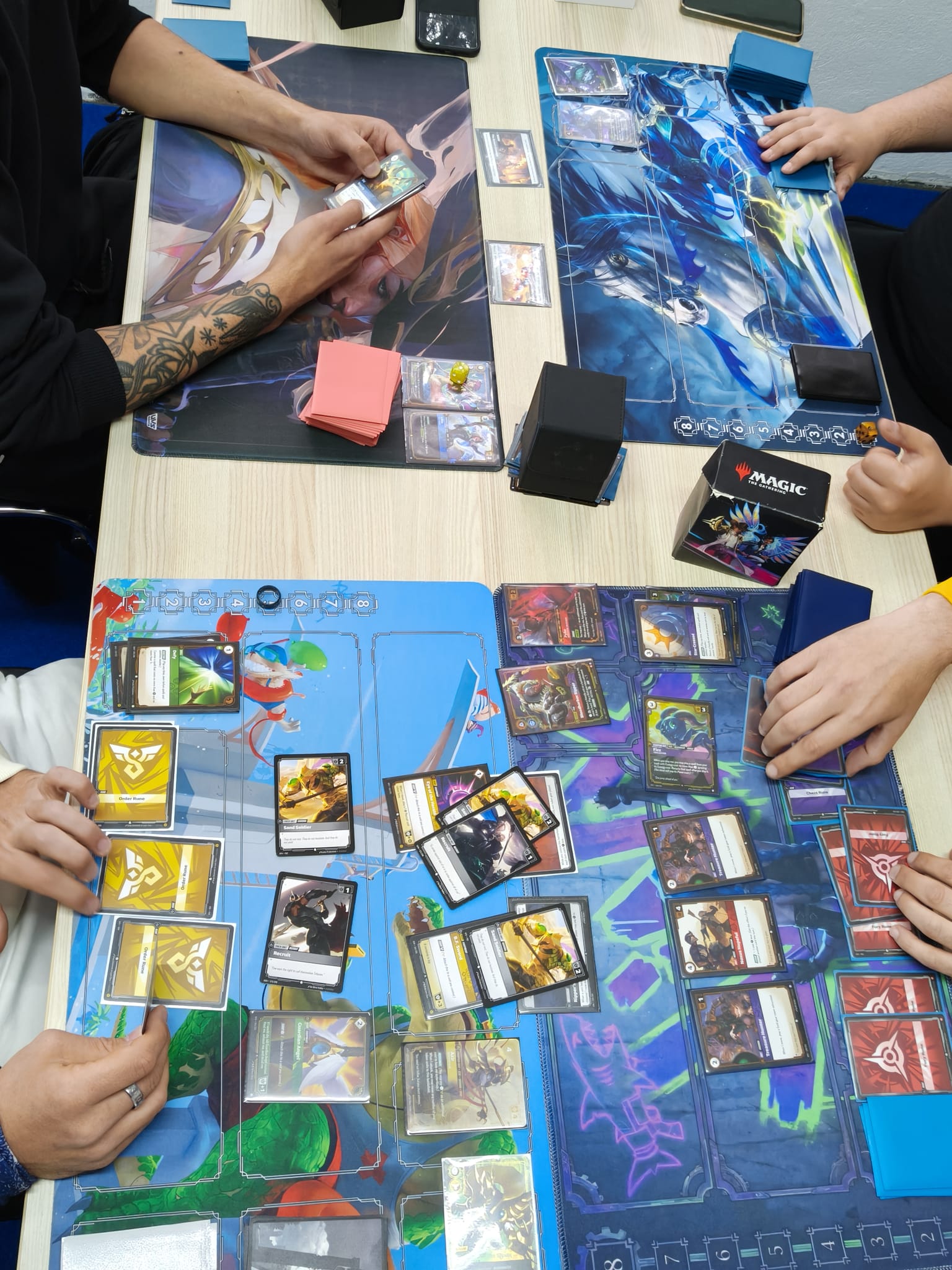 Četvero igrača igra kartašku igru za stolom u Card Board Kingdomu u Puli.