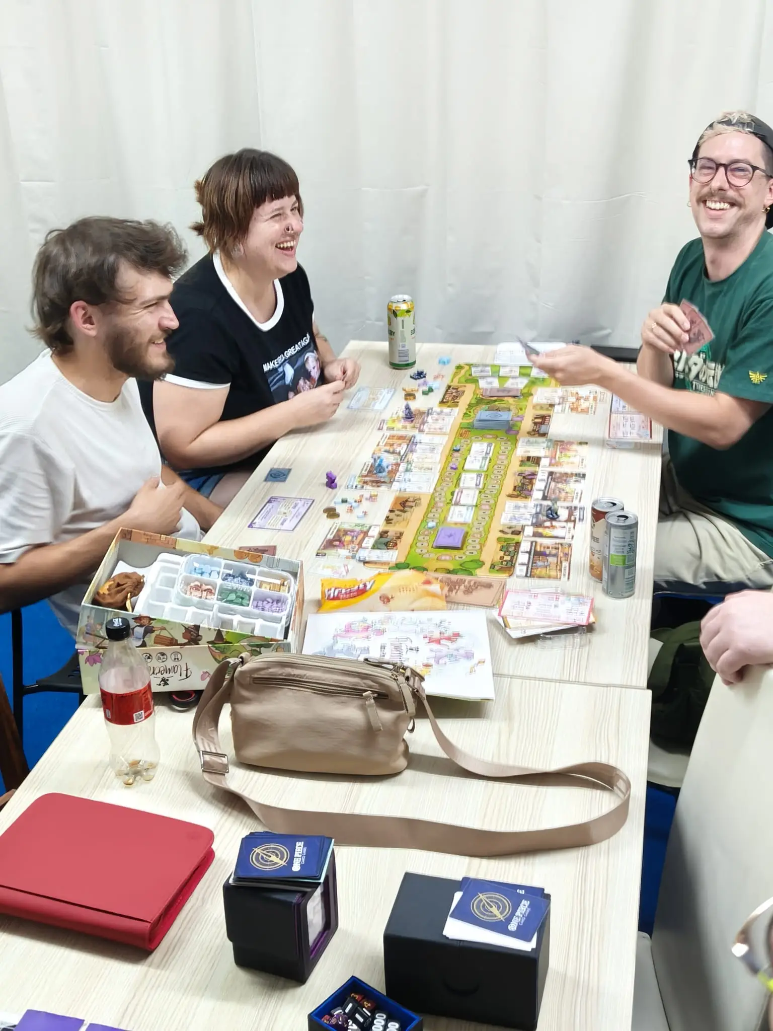 Friends laughing around a table during a board game at Card Board Kingdom in Pula.
